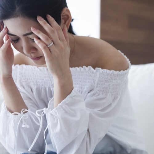 Woman holding her head with Migraine