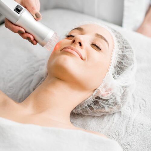 Woman receiving radio frequency treatment on face