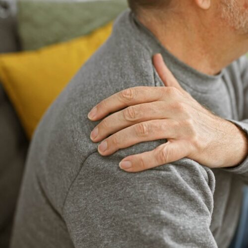 Man with Shoulder Pain holding shoulder requiring Soulder Pain Acupuncture. Shoulder-pain-treatment-acupuncture- interactive Therapies Auckland